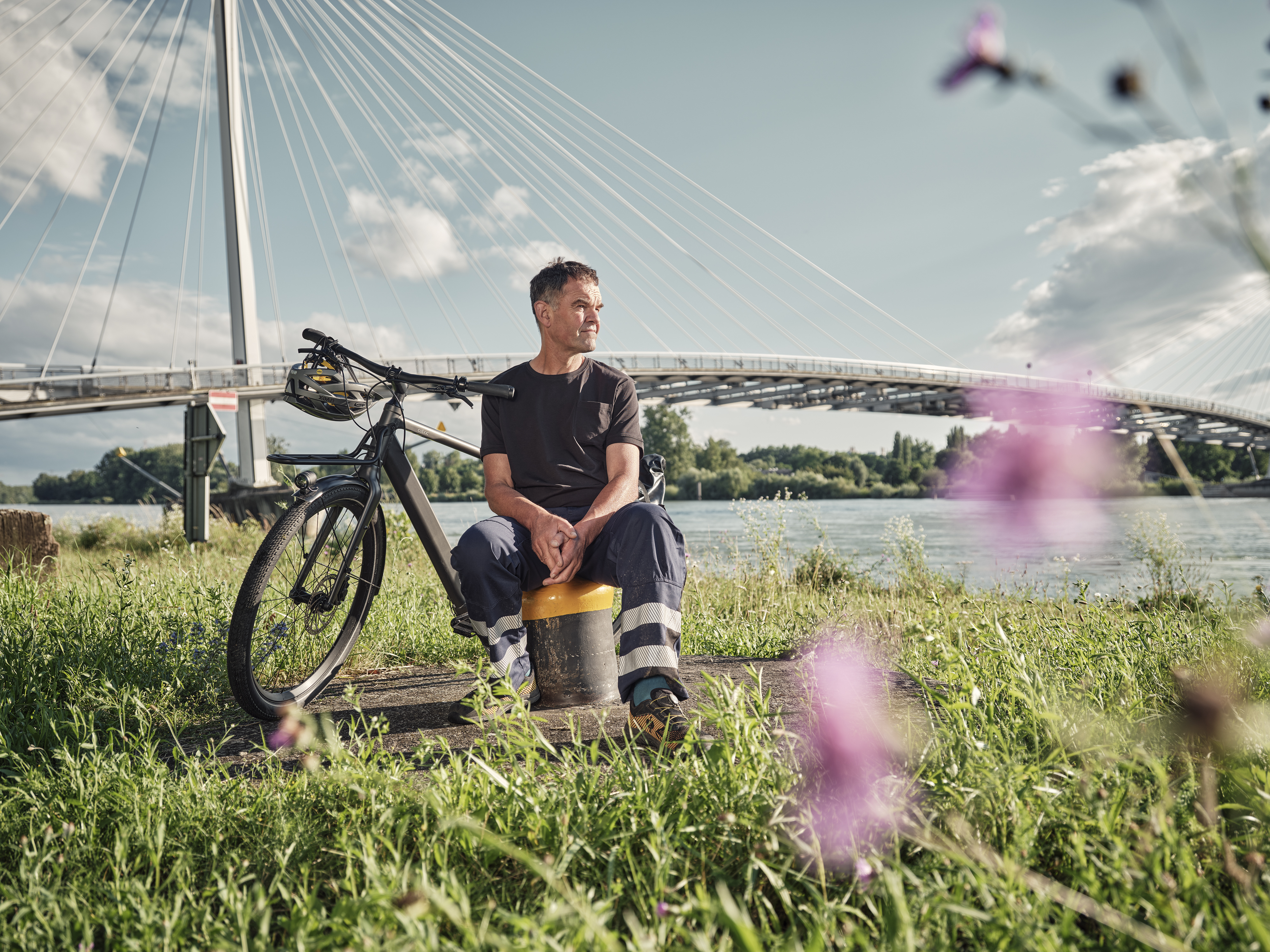 JobRadler Arbeitskleidung sitzt Wiese Brücke