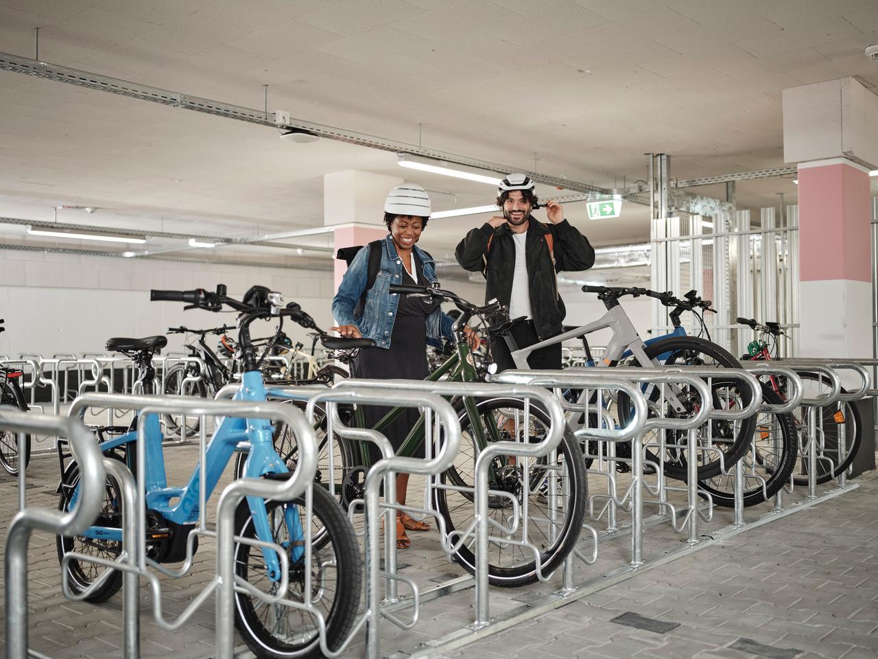 zwei Jobradler stellen Ihre Fahrräder in der Fahrradgarage ab.